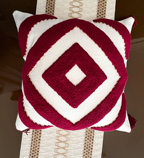 Crimsonique hand-woven cushion with intricate detailing, featuring rich textures and a warm, elegant hue for a cozy and stylish accent.